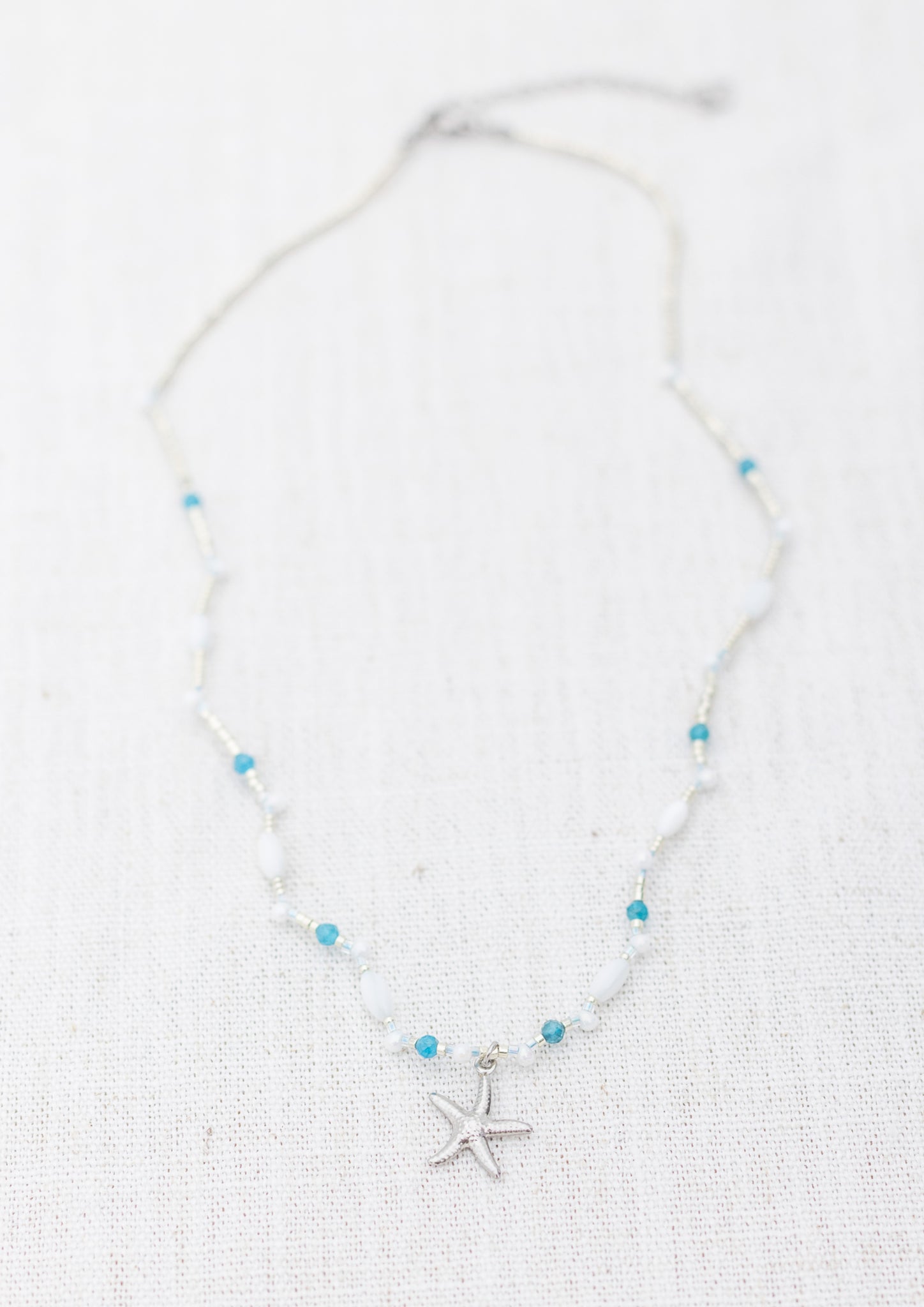 Intuitive Charms Delphina's Song Apatite Braided natural Crystal beaded custom necklace in silver on a light fabric background rectangle version