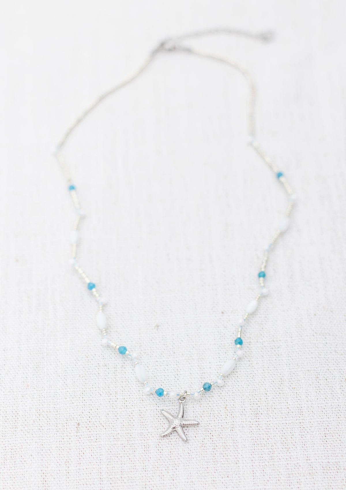 Intuitive Charms Delphina's Song Apatite Braided natural Crystal beaded custom necklace in silver on a light fabric background rectangle version