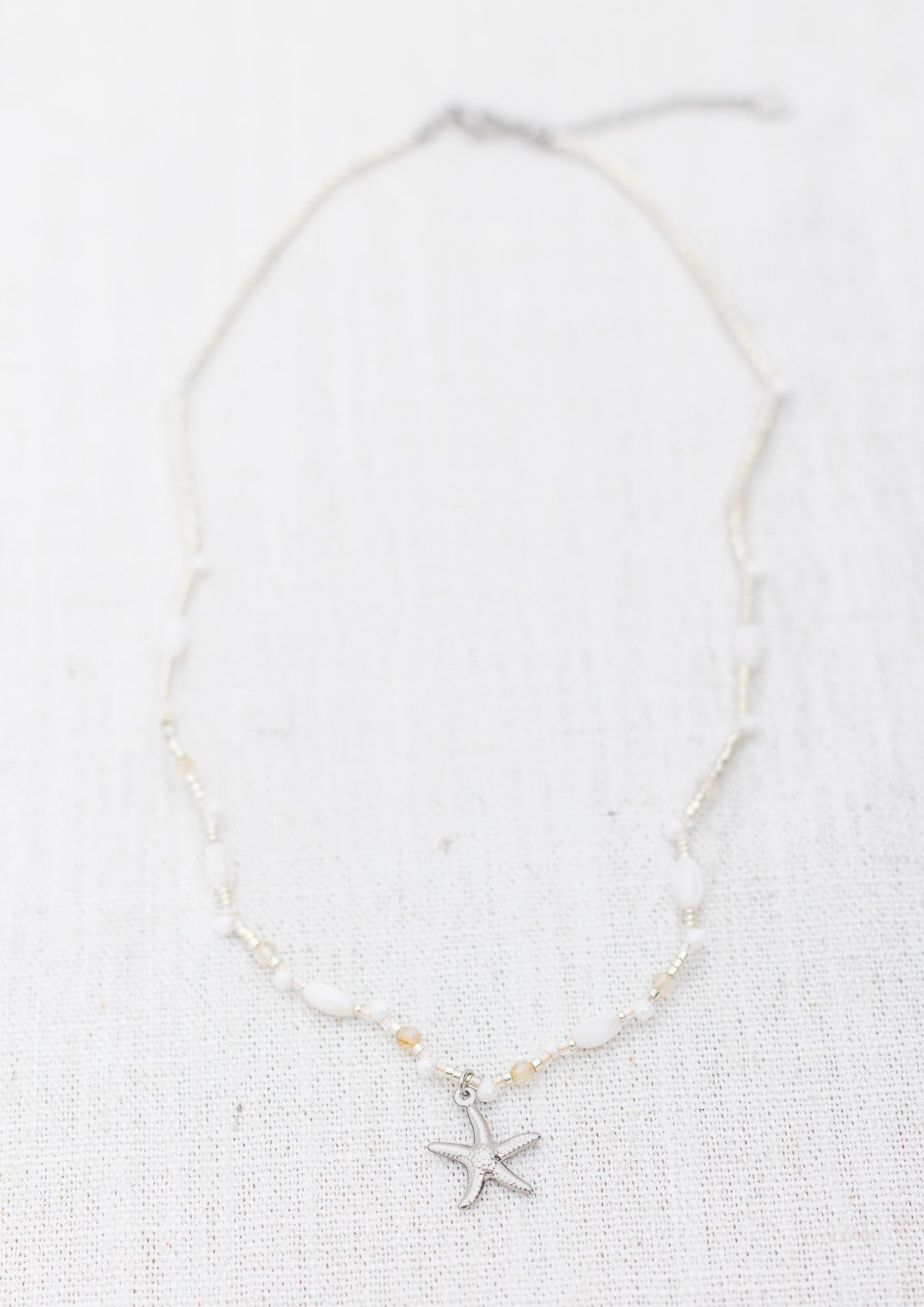 Intuitive Charms Eos's Song Citrine Braided natural Crystal beaded custom Bracelet in silver and clasp extension on a light fabric background rectangle view
