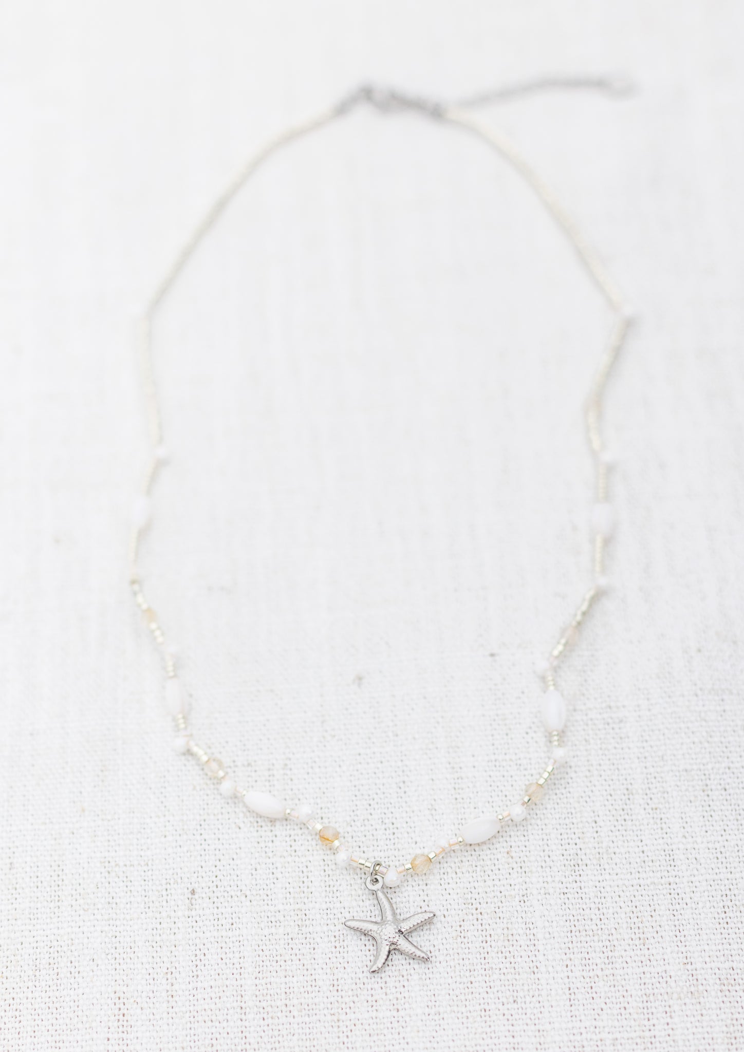 Intuitive Charms Eos's Song Citrine Braided natural Crystal beaded custom Bracelet in silver and clasp extension on a light fabric background rectangle view