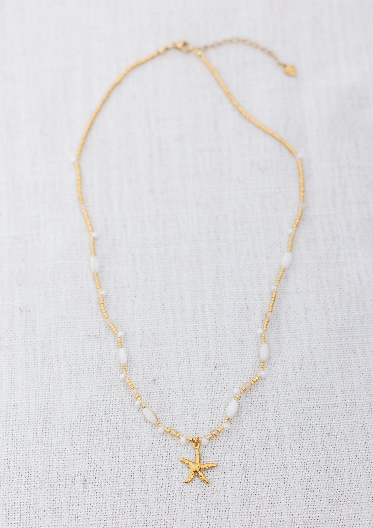 Intuitive Charms Eos's Song Citrine Braided natural Crystal beaded custom Bracelet in gold and clasp extension on a light fabric background rectangle view