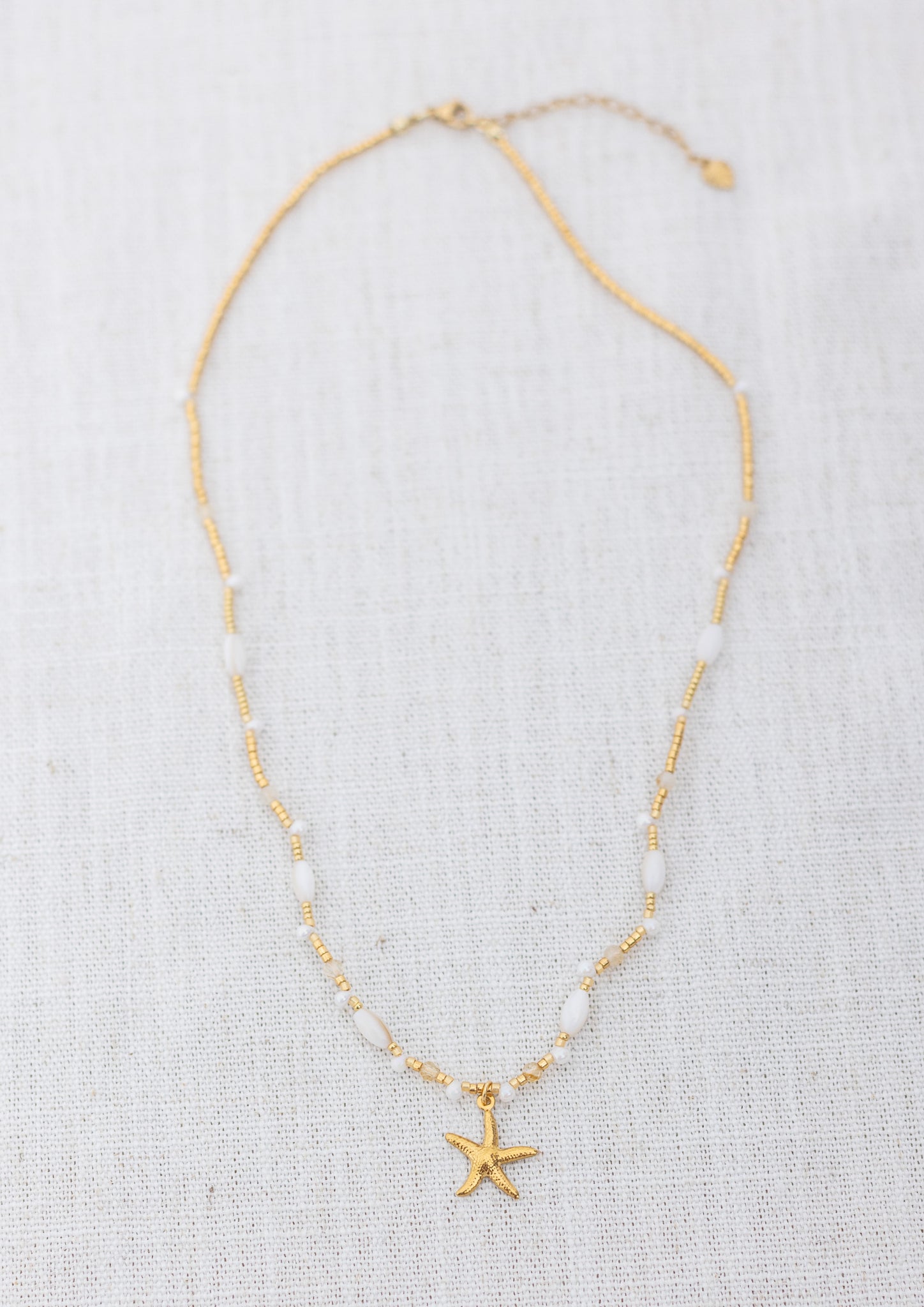 Intuitive Charms Eos's Song Citrine Braided natural Crystal beaded custom Bracelet in gold and clasp extension on a light fabric background rectangle view