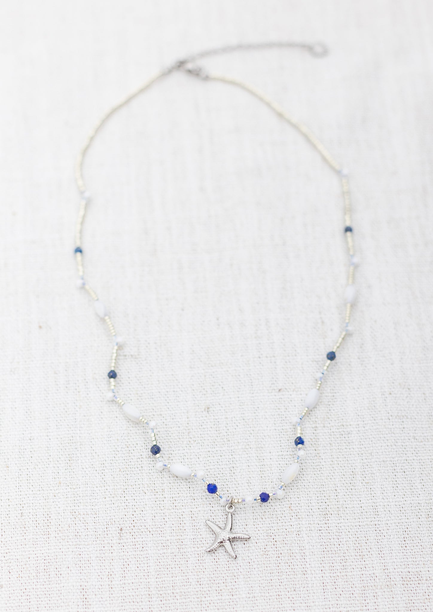 Intuitive Charms Amphitrite's Song Lapis Lazuli Braided natural Crystal beaded custom Bracelet in silver on a light fabric background rectangle version