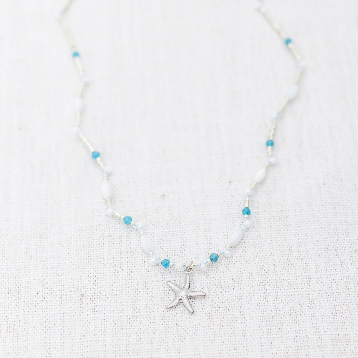 Intuitive Charms Delphina's Song Apatite Braided natural Crystal beaded custom necklace in silver on a light fabric background