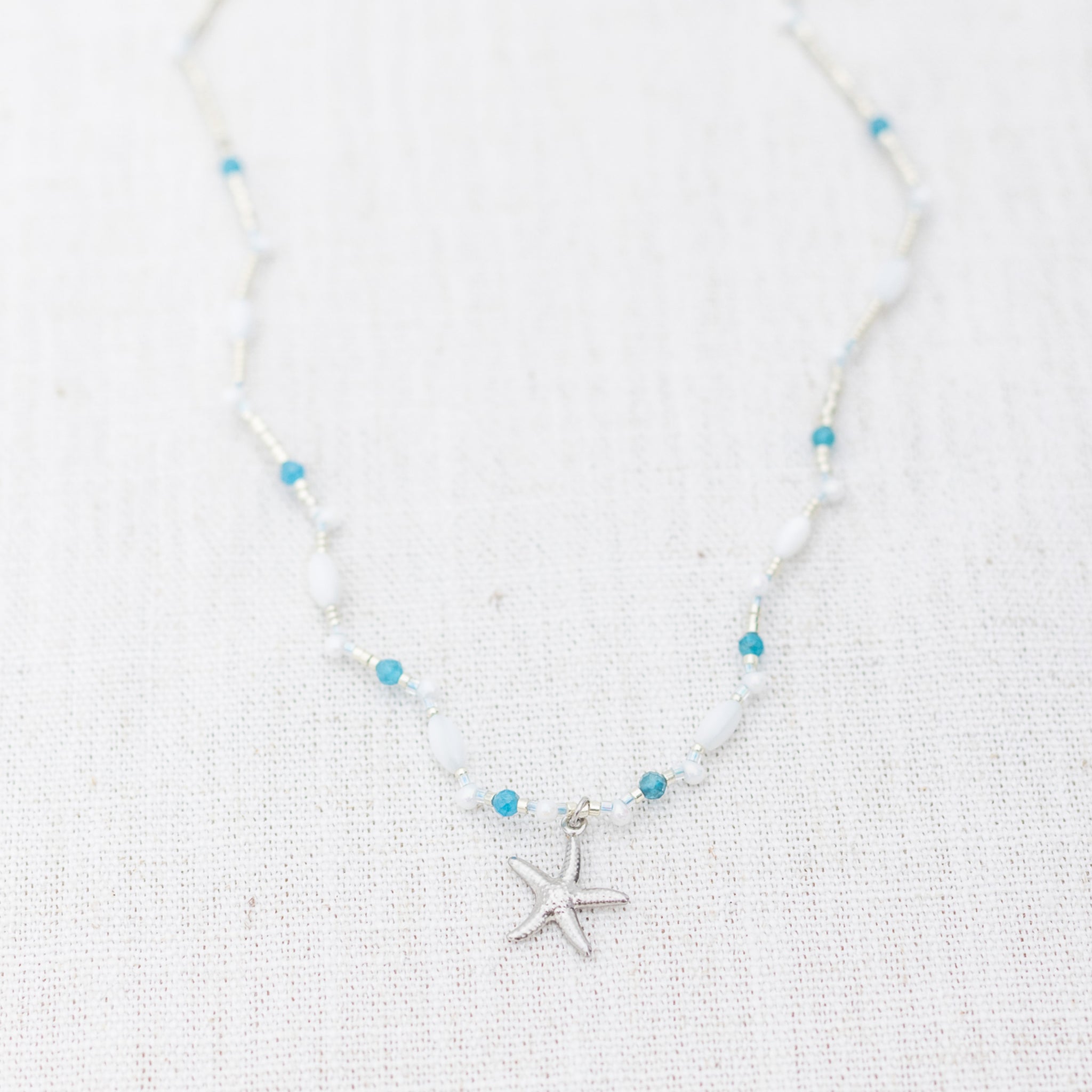 Intuitive Charms Delphina's Song Apatite Braided natural Crystal beaded custom necklace in silver on a light fabric background