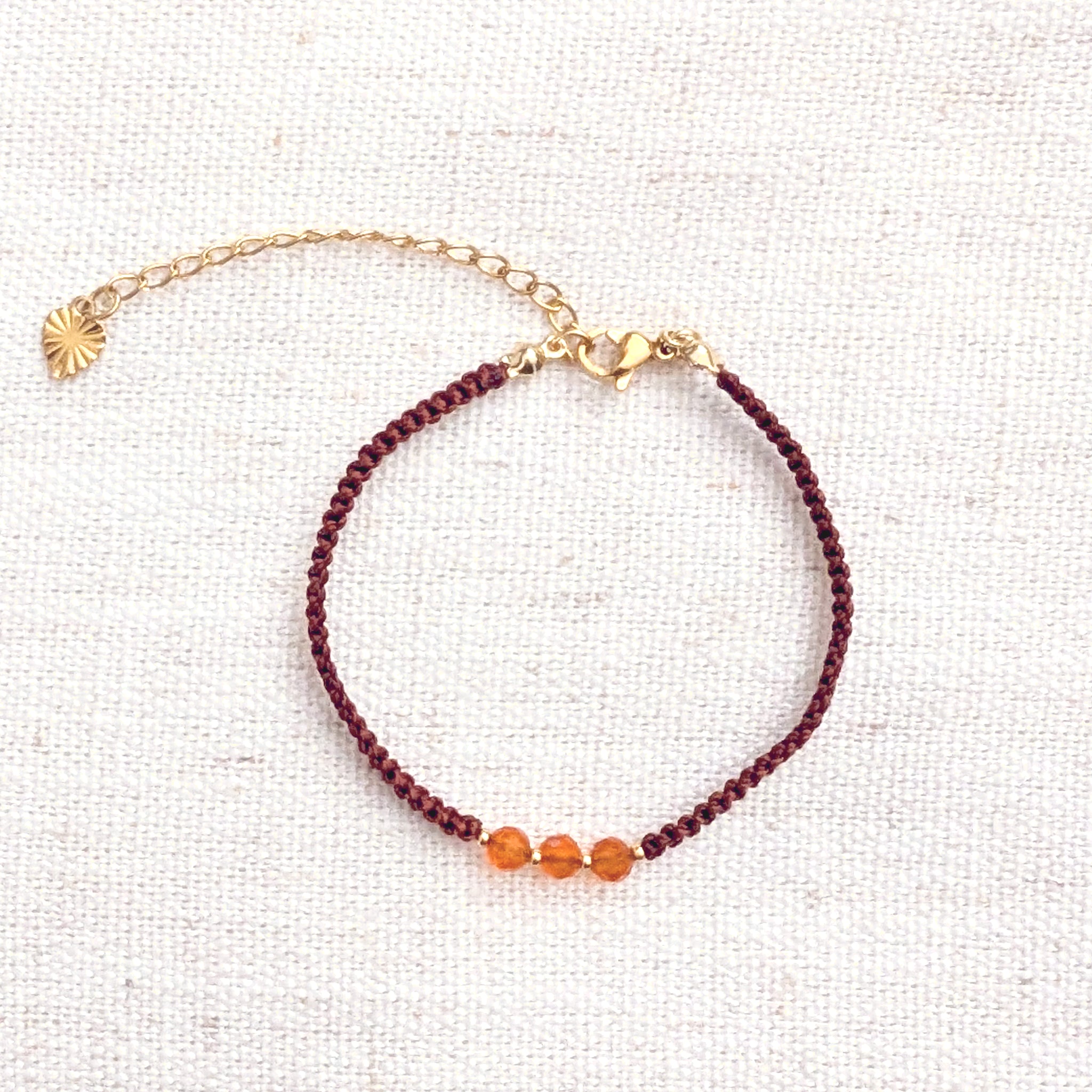 Intuitive Charms Coralia's Guard Carnelian Braided natural Crystal beaded custom Bracelet in silver and red cord and gold clasp extension on light fabric background