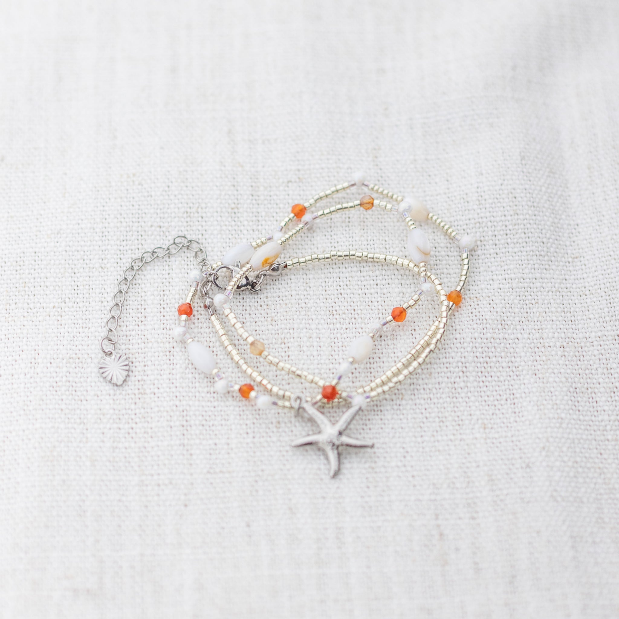 Intuitive Charms Coralia's Song Carnelian Braided natural Crystal beaded custom necklace in silver clasp extension on a light fabric background in wrapped version