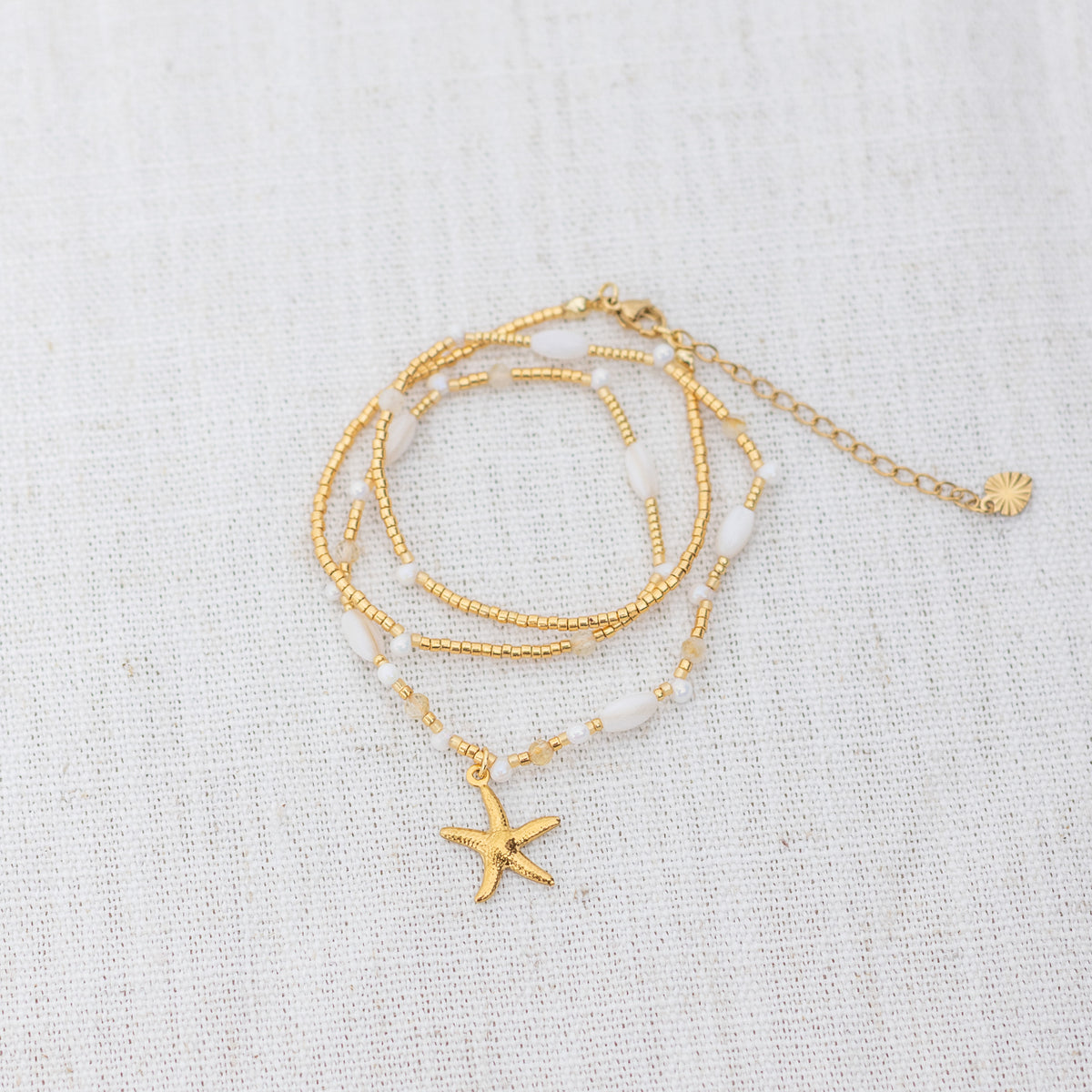 Intuitive Charms Eos's Song Citrine Braided natural Crystal beaded custom Bracelet in gold and clasp extension on a light fabric background wrapped version