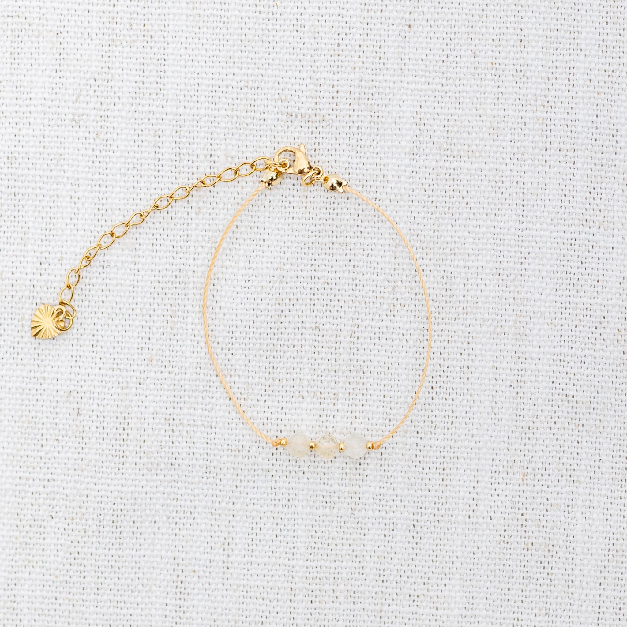 Intuitive Charms Eos's Mist Citrine Braided natural Crystal beaded custom Bracelet in gold and yellow cord and clasp extension on a light fabric background