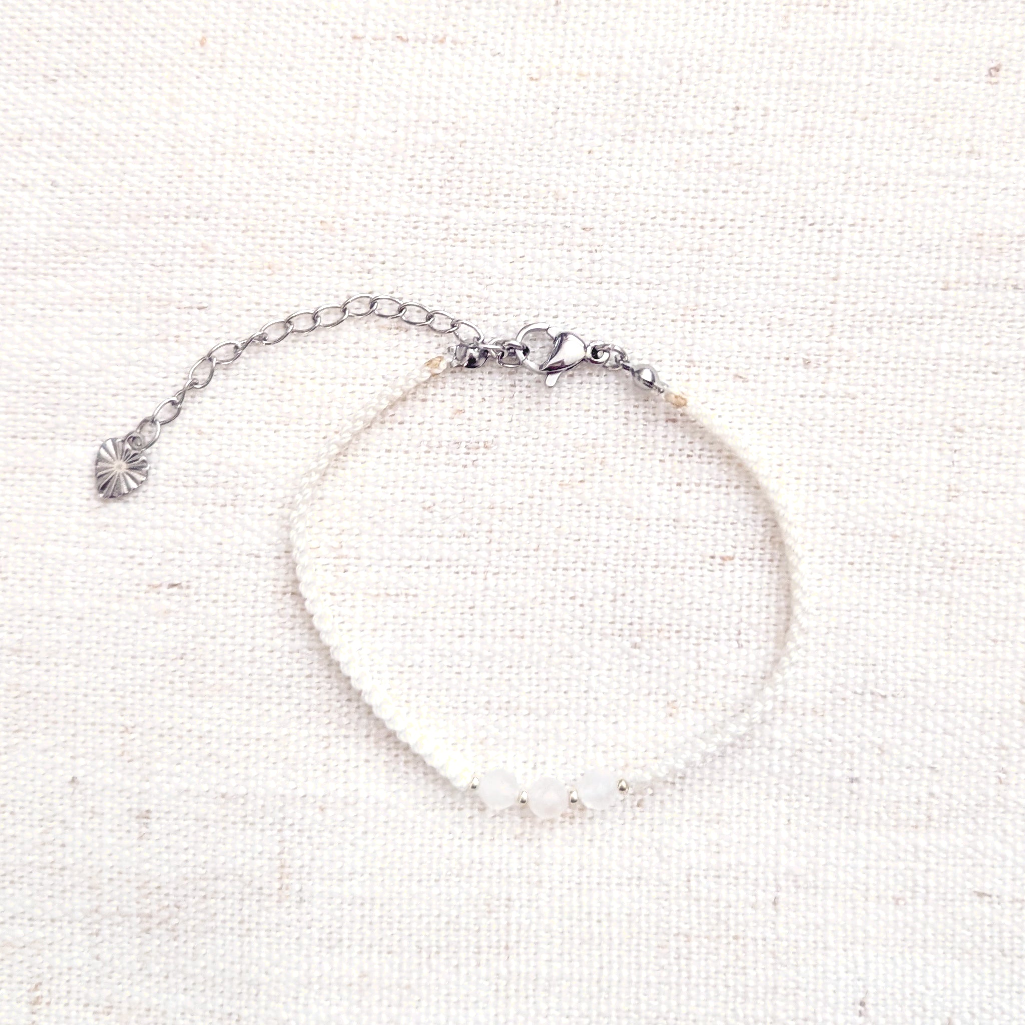 Intuitive Charms Selene's Guard Moonstone Braided natural Crystal beaded custom Bracelet in silver and white cord and clasp extension on a light fabric background
