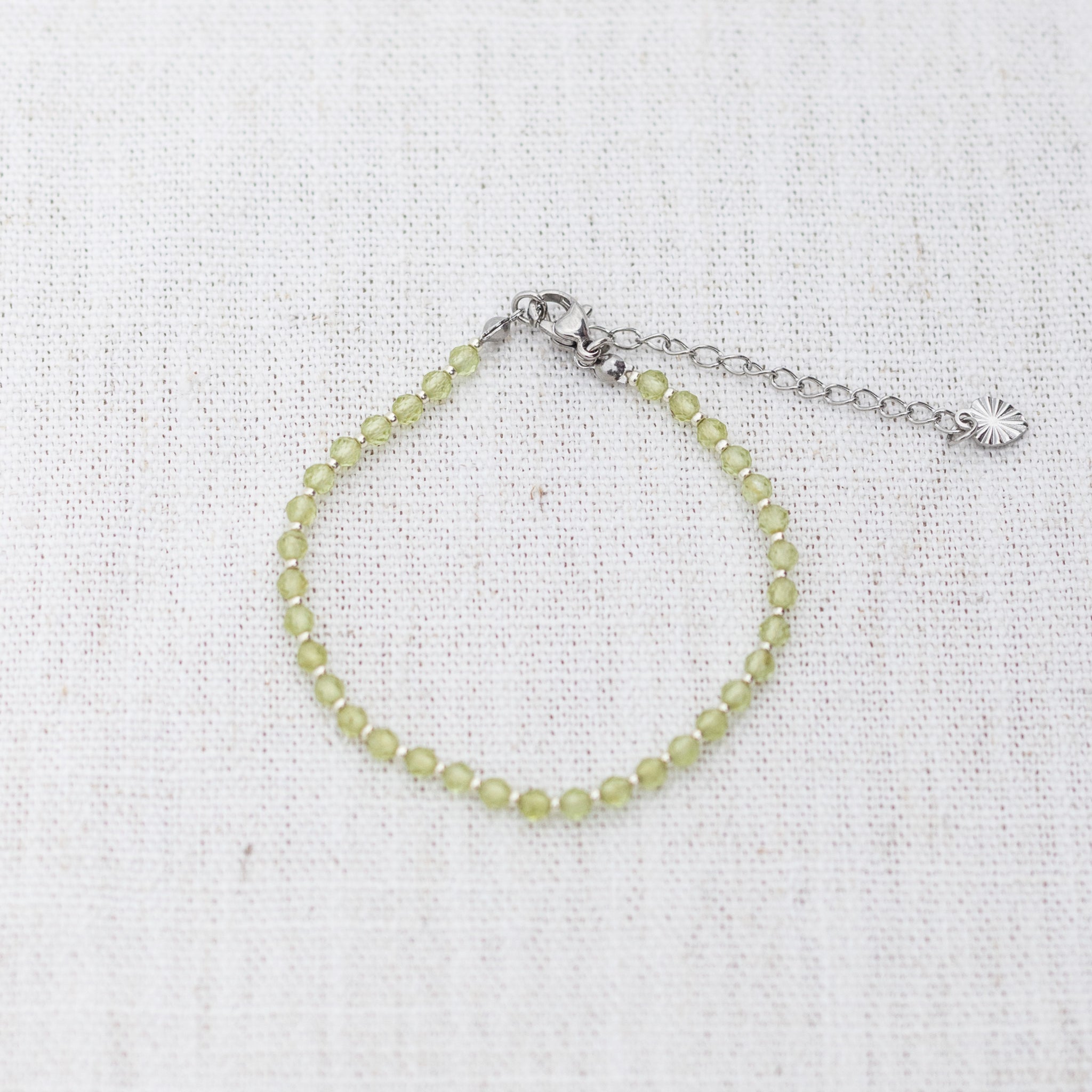 Intuitive Charms Nerina's Glow Peridot Braided natural Crystal beaded custom Bracelet in silver and light mint cord and clasp extension on a light fabric background