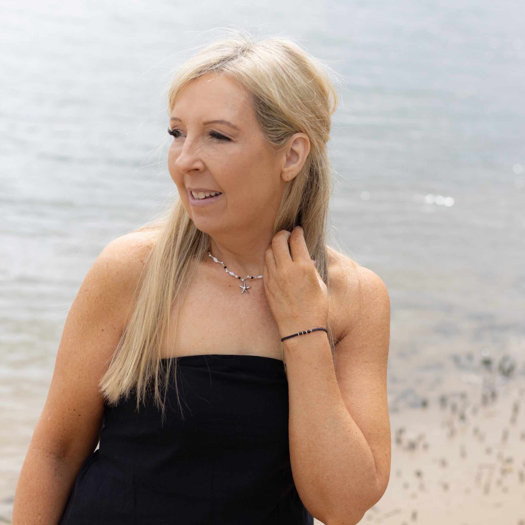 Intuitive Charms Ceto's Guard Black tourmaline Braided natural Crystal beaded custom Bracelet in silver and black cord on a model looking to left with necklace