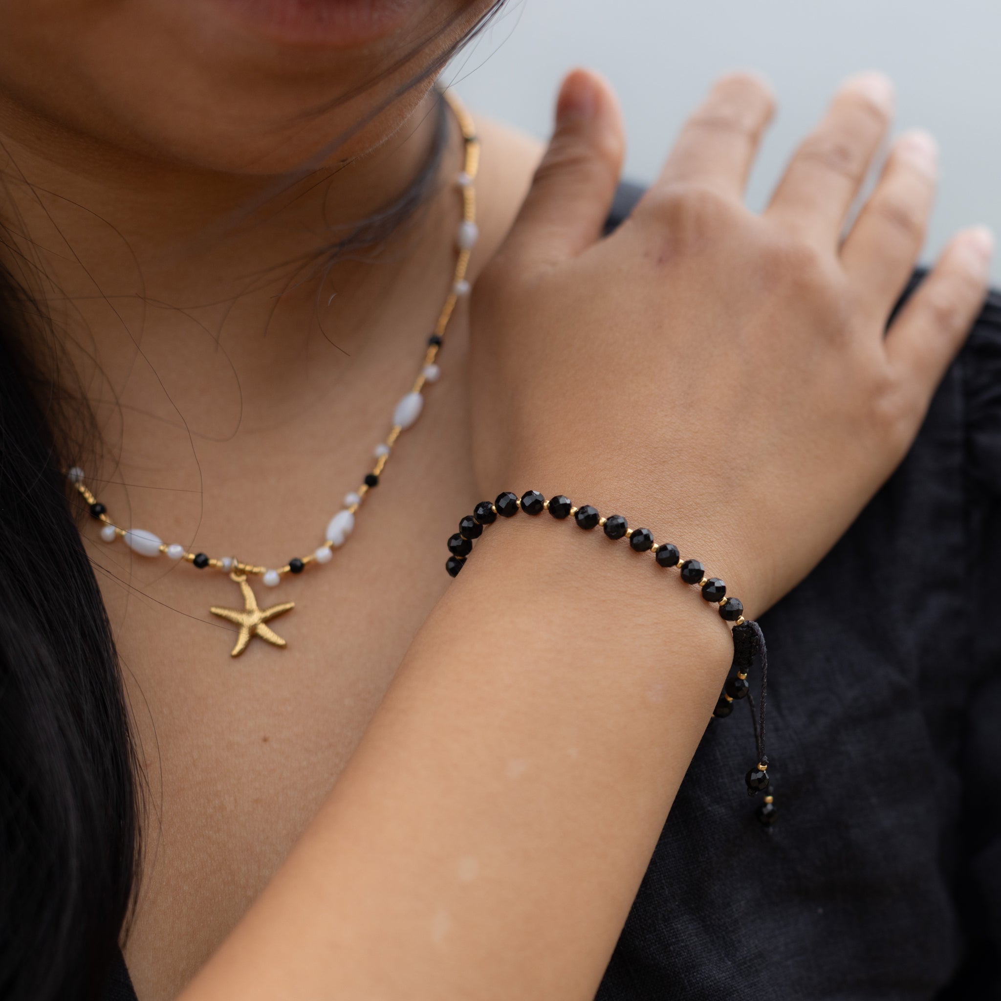 Intuitive Charms Ceto's Glow Apatite Braided natural Crystal beaded custom Bracelet in gold and black cord on a model with necklace