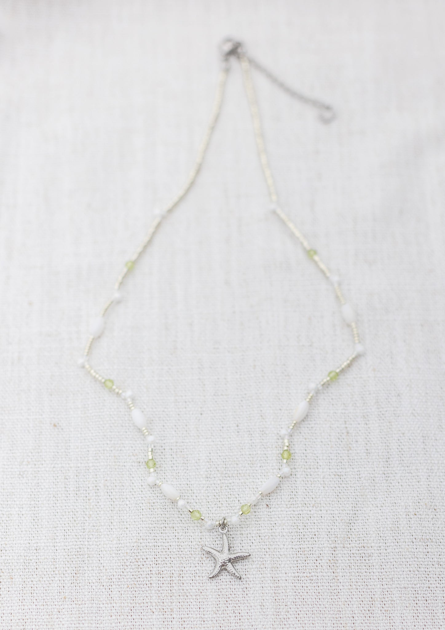 Intuitive Charms Nerina's Song Peridot natural Crystal beaded custom Bracelet in silver on a light fabric background rectangle version