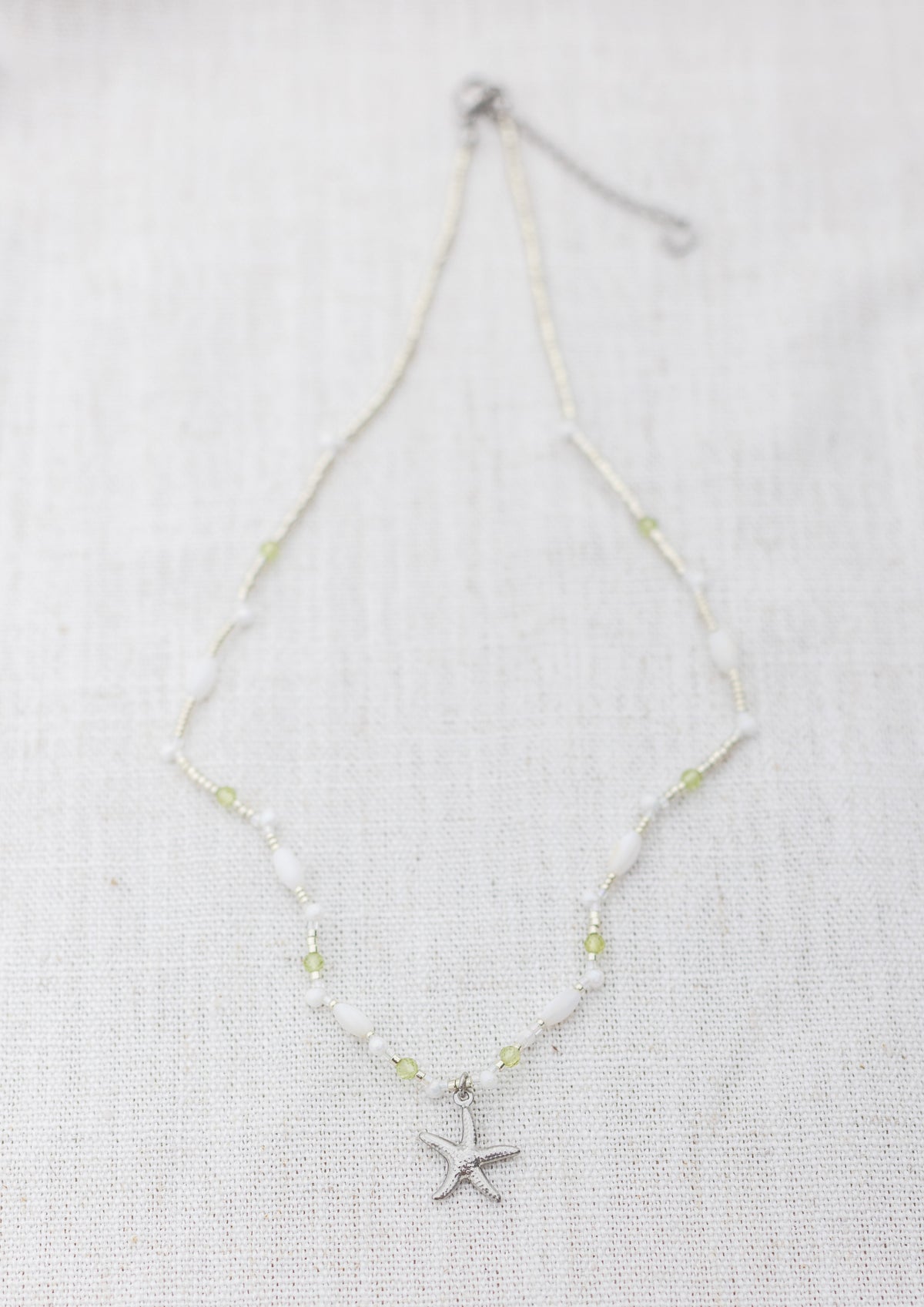 Intuitive Charms Nerina's Song Peridot natural Crystal beaded custom Bracelet in silver on a light fabric background rectangle version