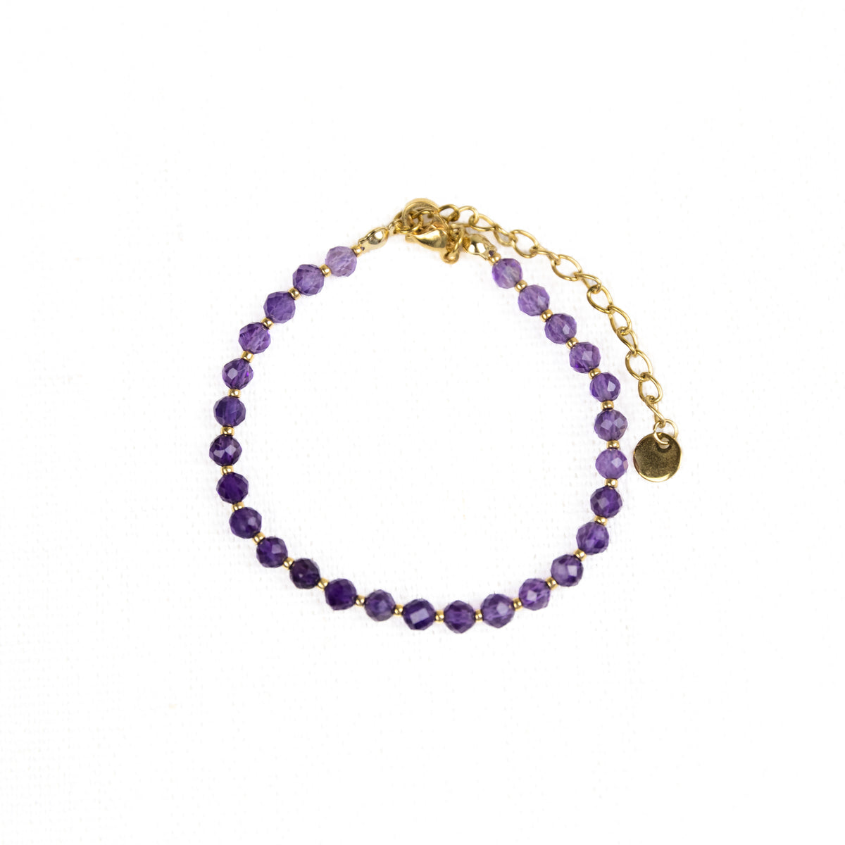Intuitive Charms Sophia's Glow Amethyst Braided natural Crystal beaded custom Bracelet in gold and purple cord and stainless steel clasp extension on a light fabric background