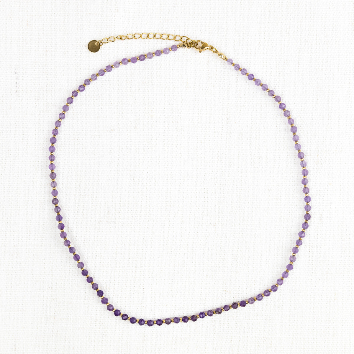 Intuitive Charms Sophia's song Amethyst Braided natural Crystal beaded custom necklace in gold and purple cord and stainless steel clasp extension on a light fabric background