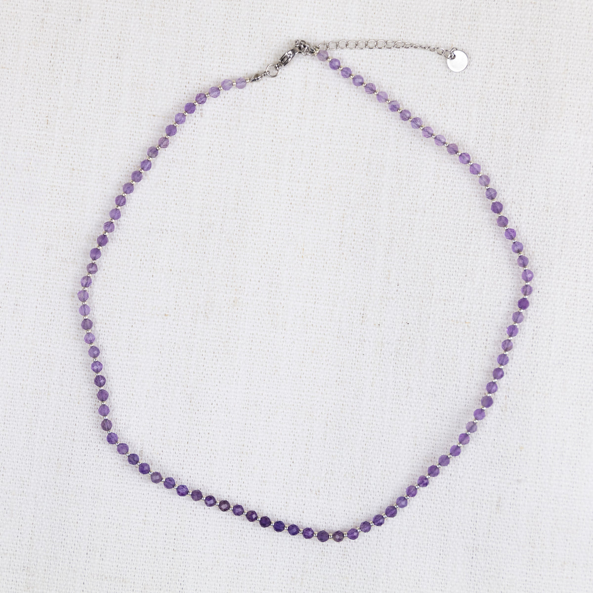 Intuitive Charms Sophia's song Amethyst Braided natural Crystal beaded custom necklace in silver and purple cord and stainless steel clasp extension on a light fabric background