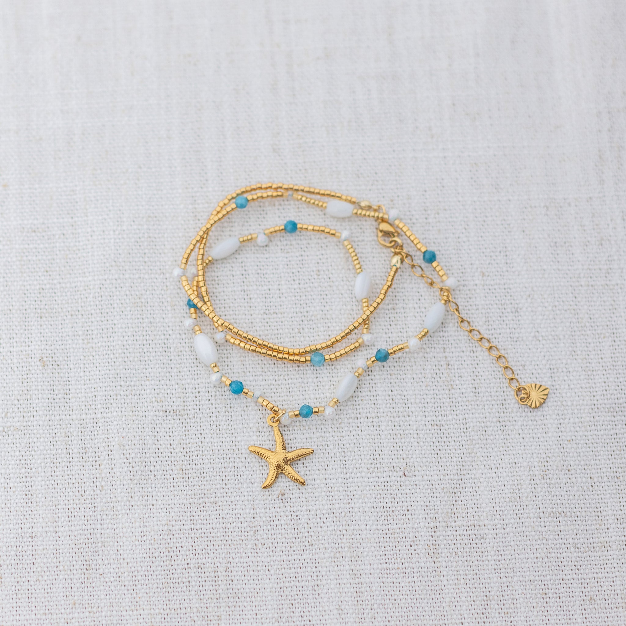 Intuitive Charms Delphina's Song Apatite Braided natural Crystal beaded custom necklace in gold on a light fabric background wrapped version