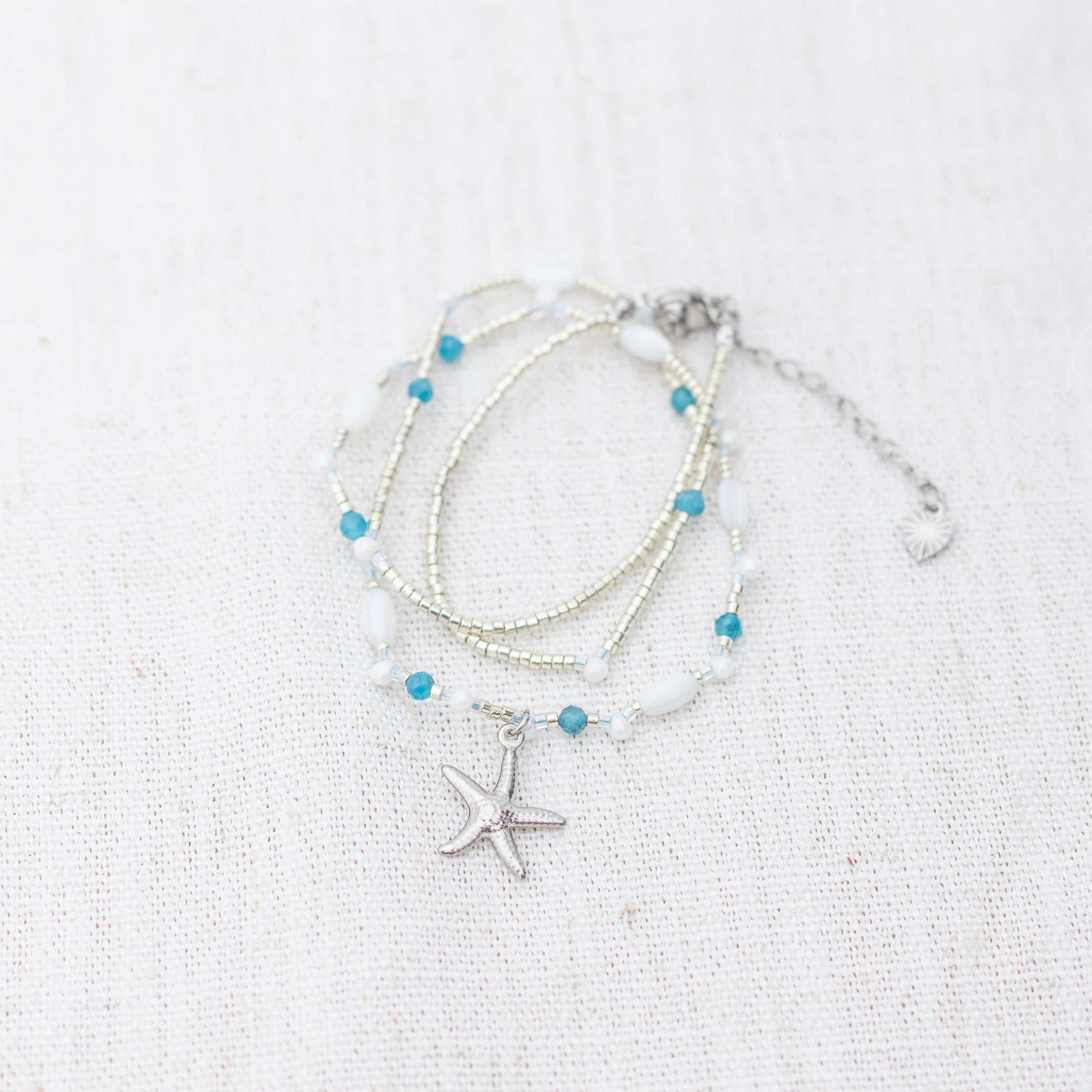 Intuitive Charms Delphina's Song Apatite Braided natural Crystal beaded custom necklace in silver on a light fabric background wrapped version