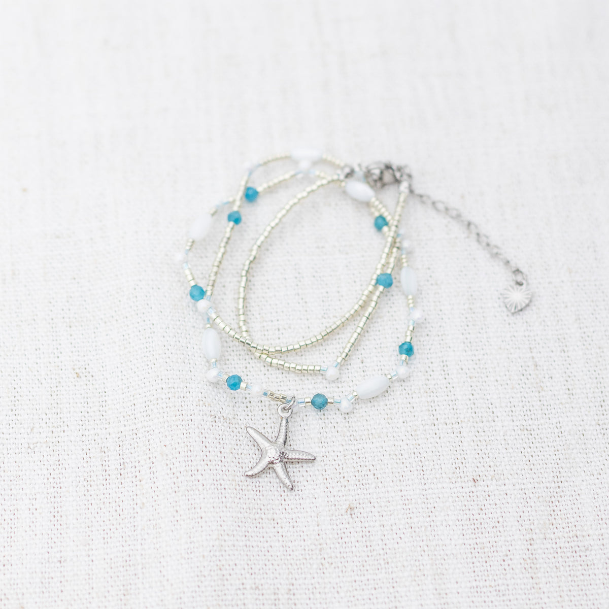 Intuitive Charms Delphina's Song Apatite Braided natural Crystal beaded custom necklace in silver on a light fabric background wrapped version