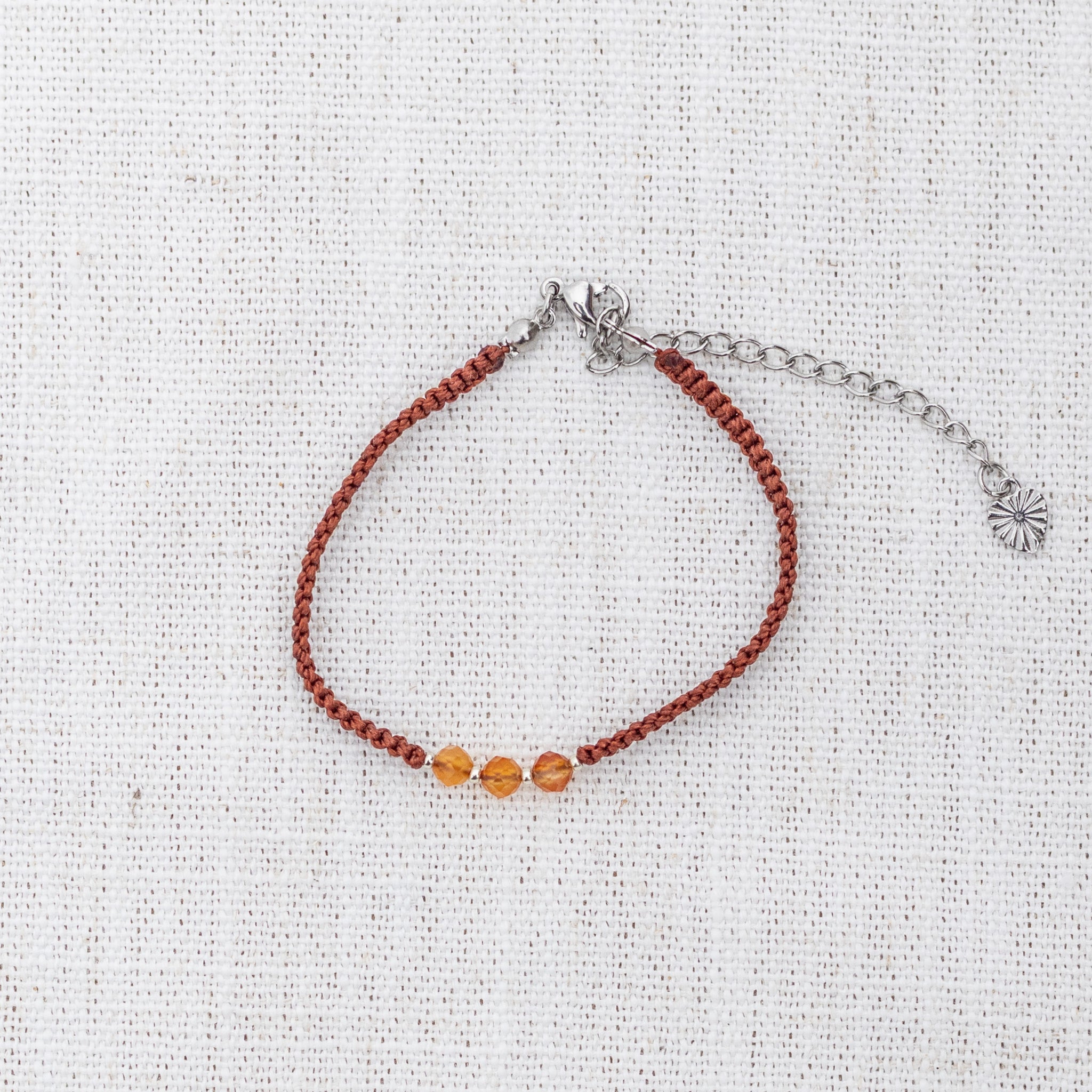 Intuitive Charms Coralia's Guard Carnelian Braided natural Crystal beaded custom Bracelet in silver and red cord and silver clasp extension on light fabric background