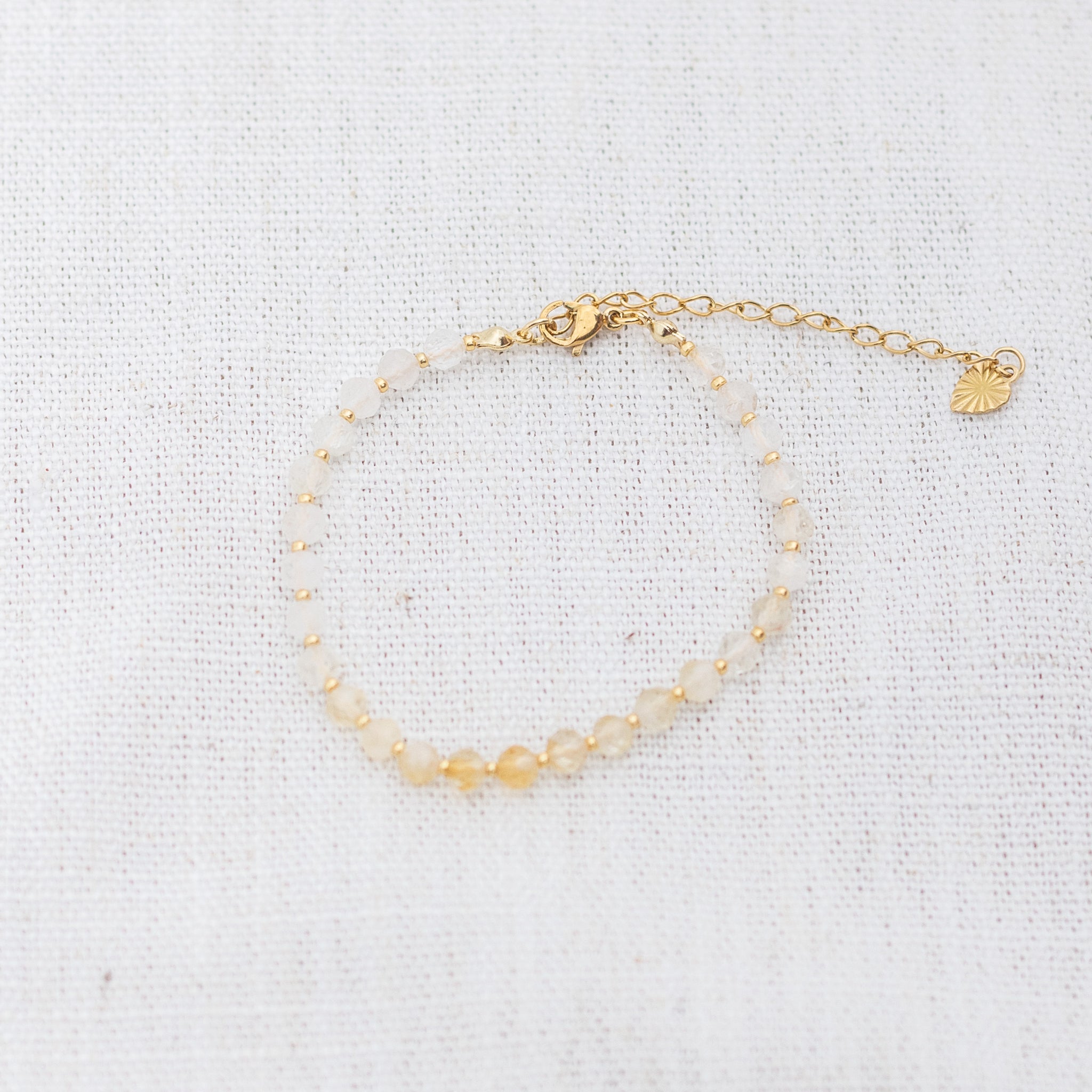 Intuitive Charms Eos's Glow Citrine Braided natural Crystal beaded custom Bracelet in gold and yellow cord and clasp extension on a light fabric background