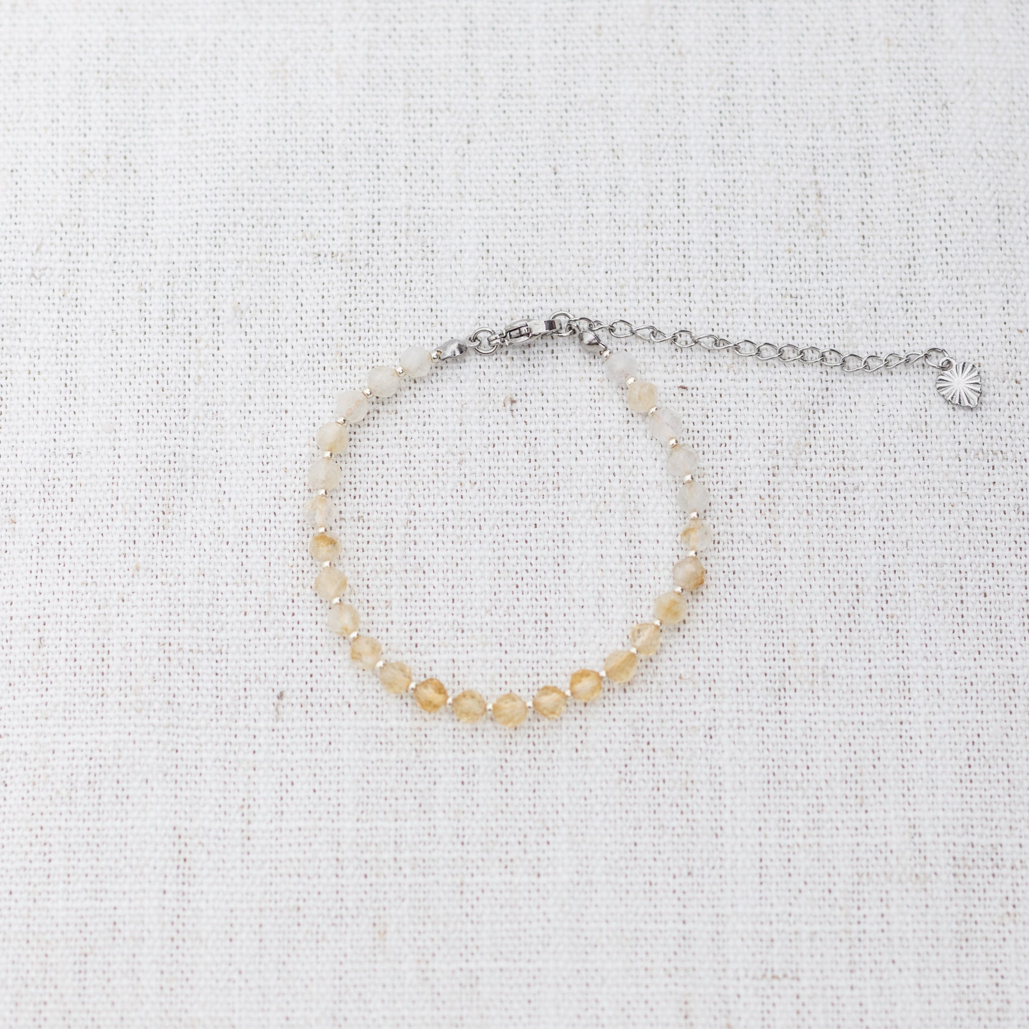 Intuitive Charms Eos's Glow Citrine Braided natural Crystal beaded custom Bracelet in silver and yellow cord and clasp extension on a light fabric background