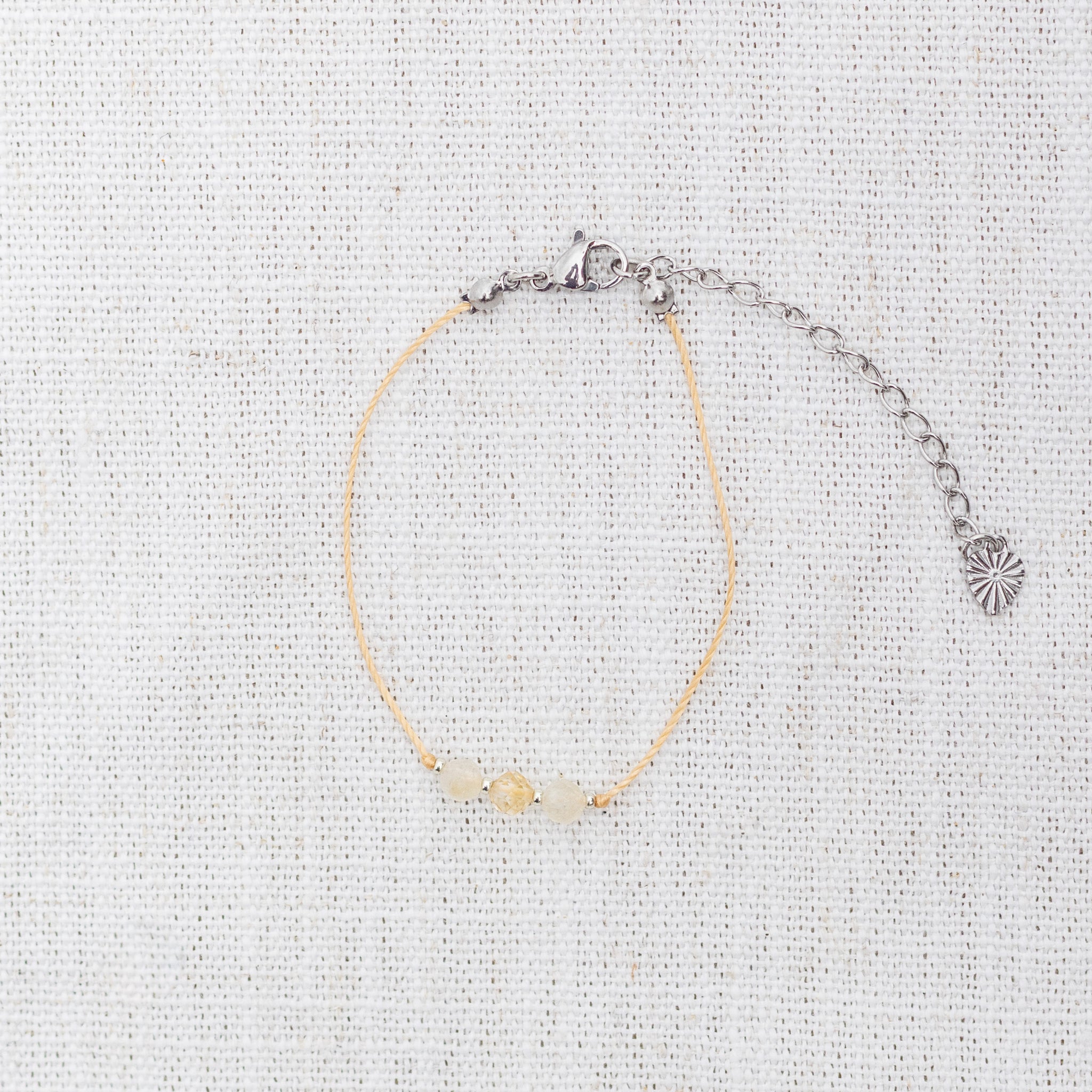 Intuitive Charms Eos's Mist Citrine Braided natural Crystal beaded custom Bracelet in silver and yellow cord and clasp extension on a light fabric background