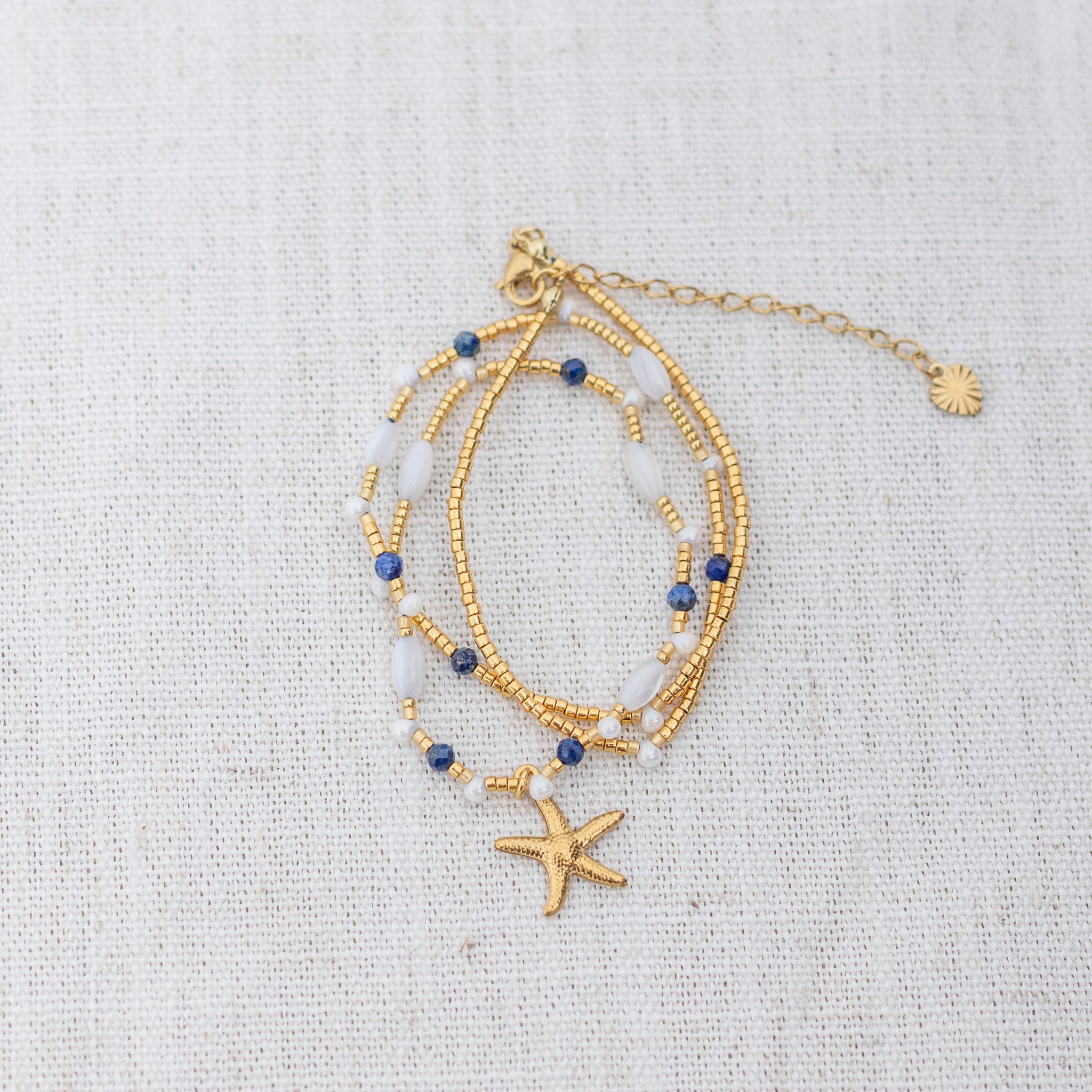 Intuitive Charms Amphitrite's Song Lapis Lazuli Braided natural Crystal beaded custom Bracelet in gold on a light fabric background wrapped version