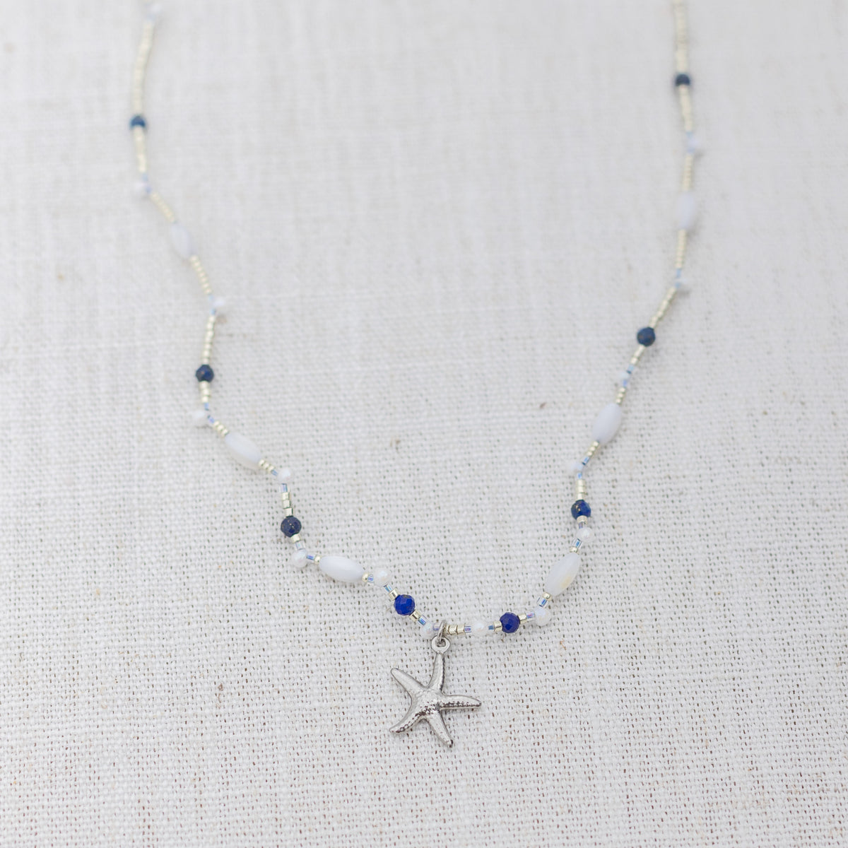 Intuitive Charms Amphitrite's Song Lapis Lazuli Braided natural Crystal beaded custom Bracelet in silver on a light fabric background
