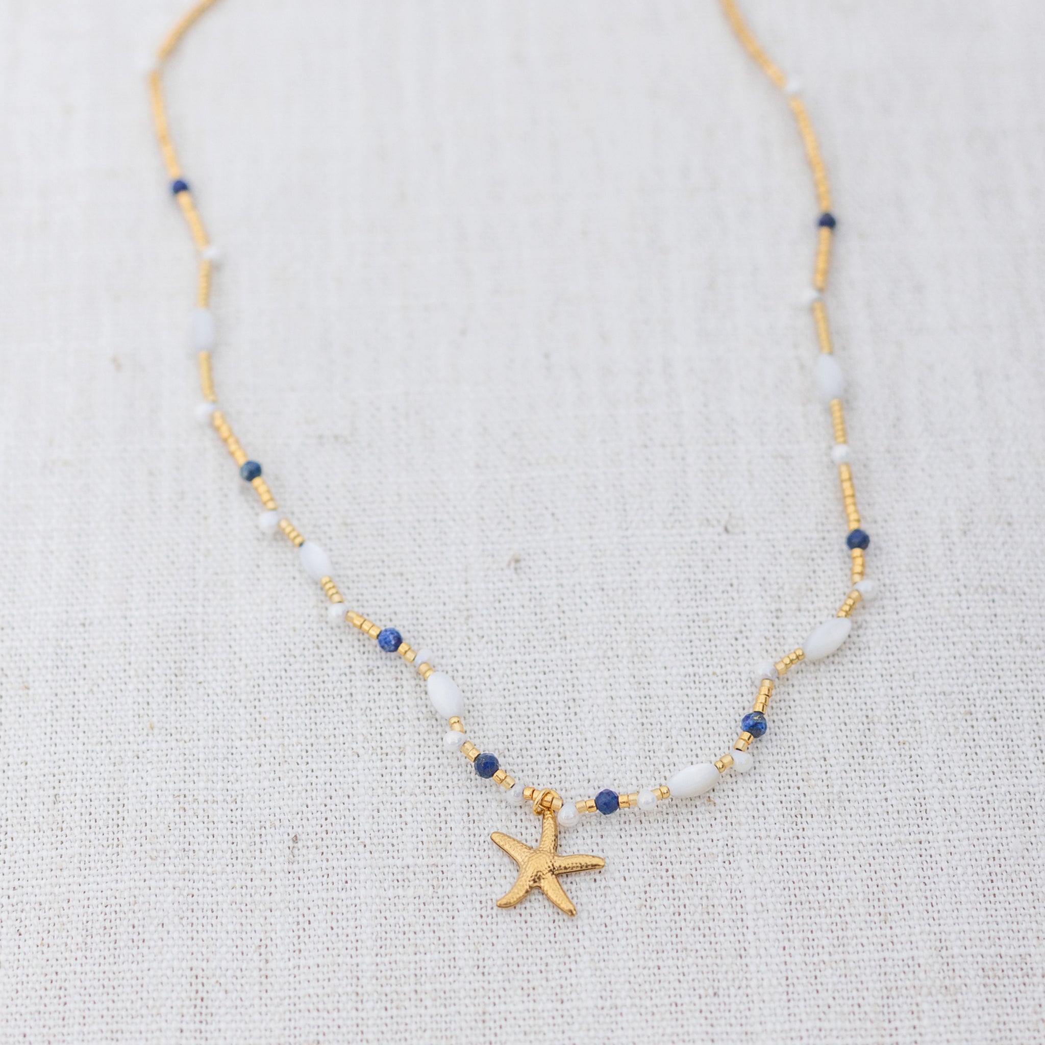 Intuitive Charms Amphitrite's Song Lapis Lazuli Braided natural Crystal beaded custom Bracelet in gold on a light fabric background
