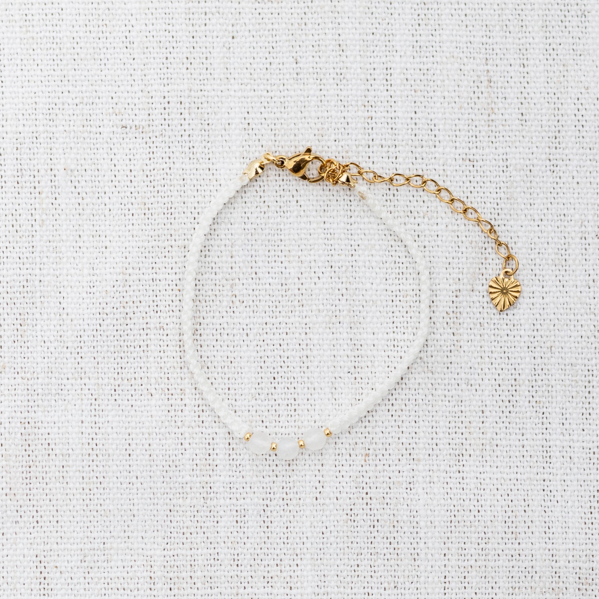 Intuitive Charms Selene's Guard Moonstone Braided natural Crystal beaded custom Bracelet in gold and white cord and clasp extension on a light fabric background