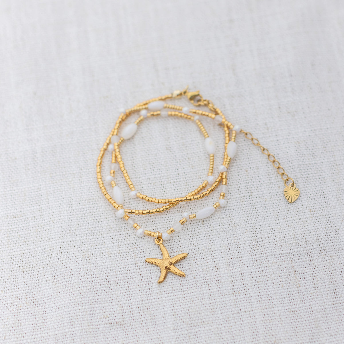 Intuitive Charms Selene's Song Moonstone natural Crystal beaded custom necklace in gold and clasp extension on a light fabric background wrapped version