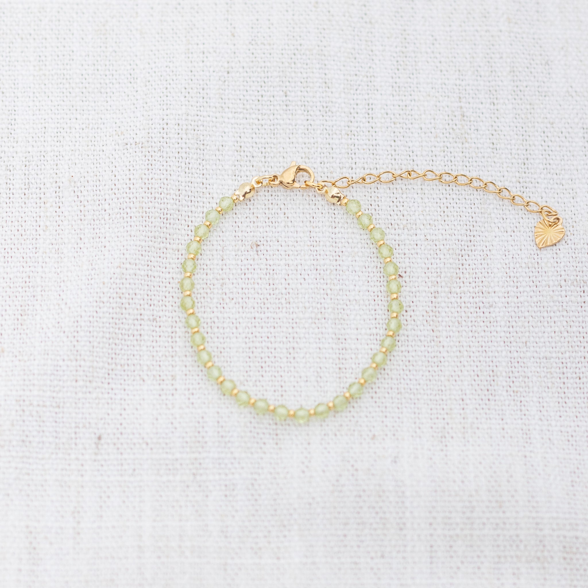 Intuitive Charms Nerina's Glow Peridot Braided natural Crystal beaded custom Bracelet in silver and light mint cord and clasp extension on a light fabric background