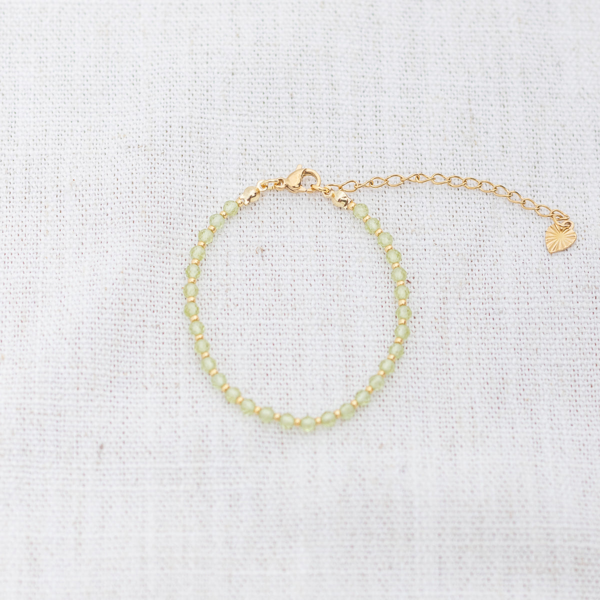 Intuitive Charms Nerina's Glow Peridot Braided natural Crystal beaded custom Bracelet in silver and light mint cord and clasp extension on a light fabric background