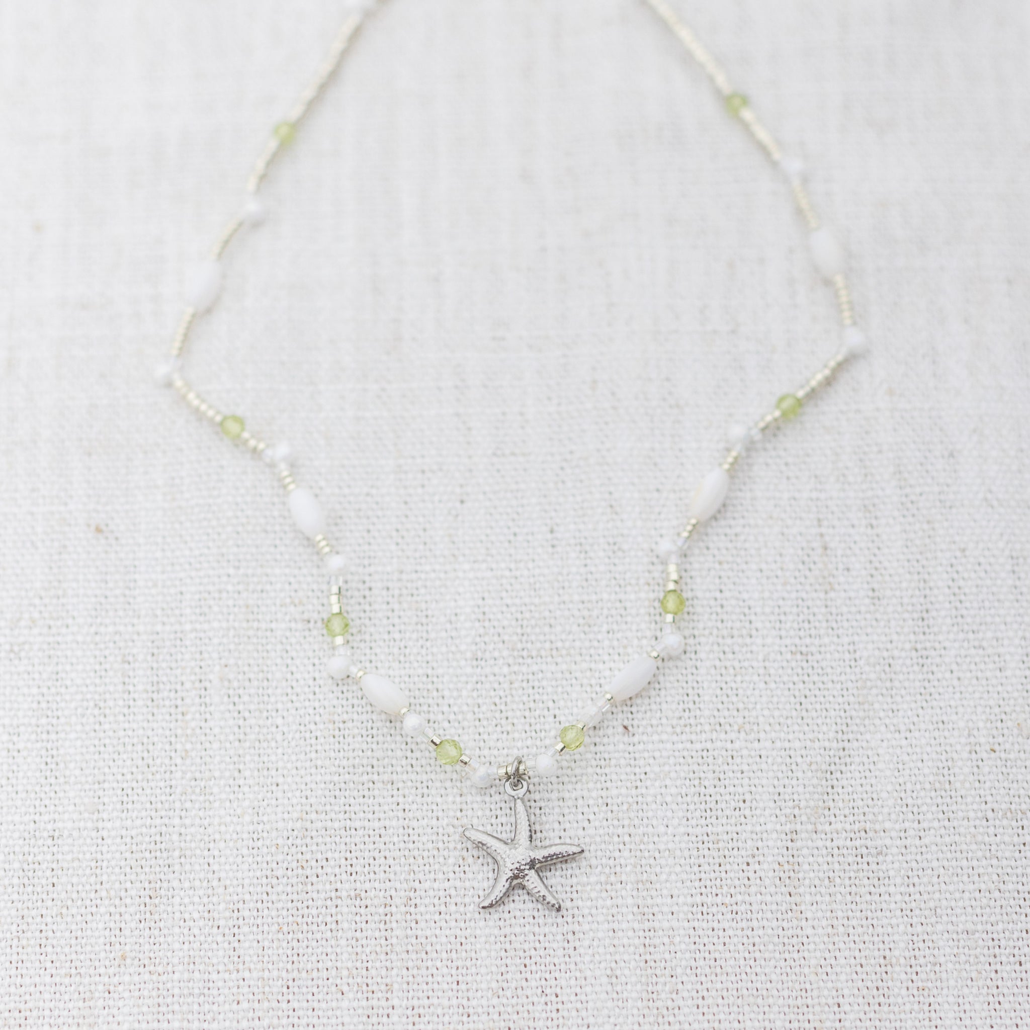 Intuitive Charms Nerina's Song Peridot natural Crystal beaded custom Bracelet in silver on a light fabric background