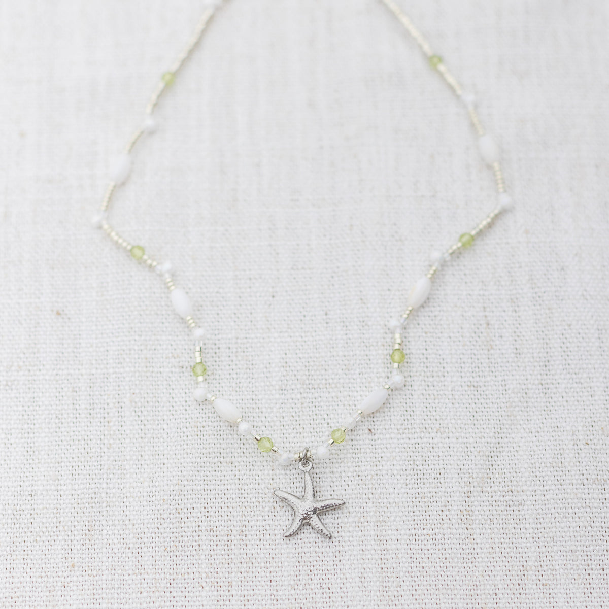 Intuitive Charms Nerina's Song Peridot natural Crystal beaded custom Bracelet in silver on a light fabric background