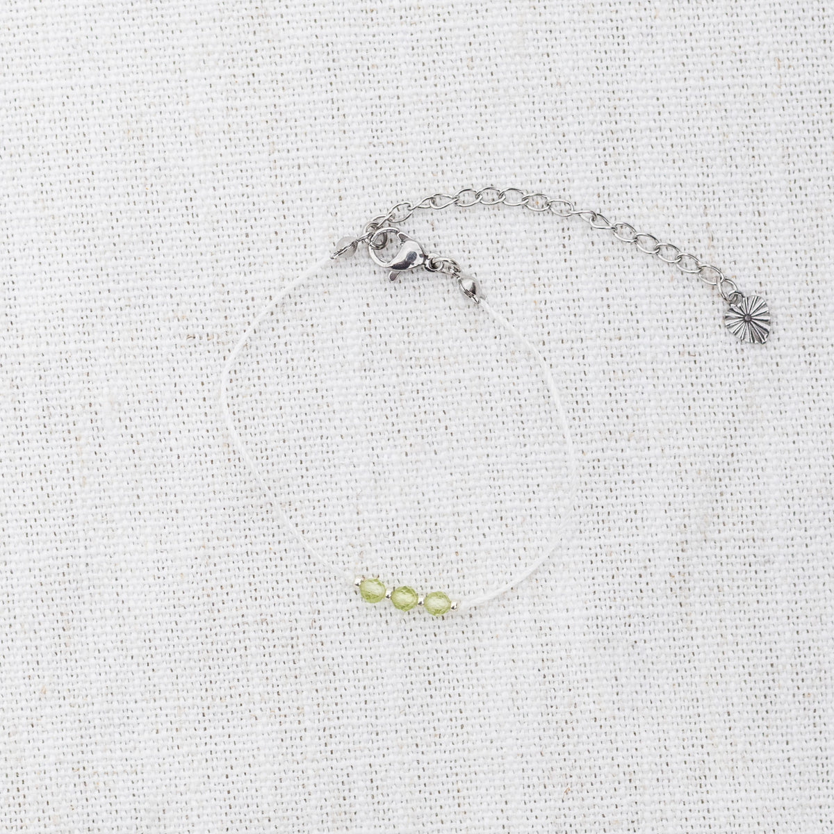 Intuitive Charms Nerina's Mist Peridot Braided natural Crystal beaded custom Bracelet in silver and light mint cord and clasp extension on a light fabric background