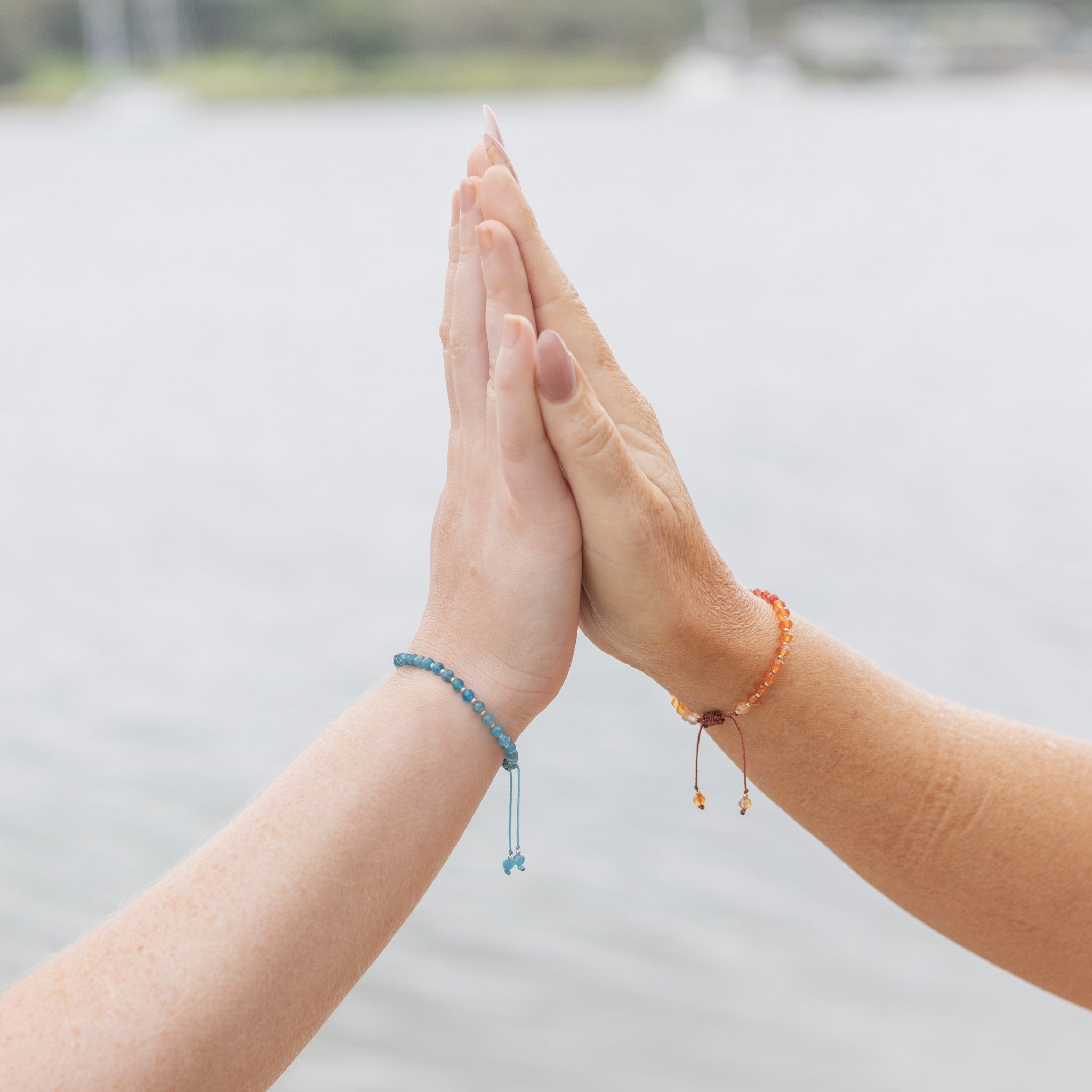 Intuitive Charms Delphina's Glow Apatite Braided natural Crystal beaded custom Bracelet in silver and blue cord on a model hand zoom close up with carnelian