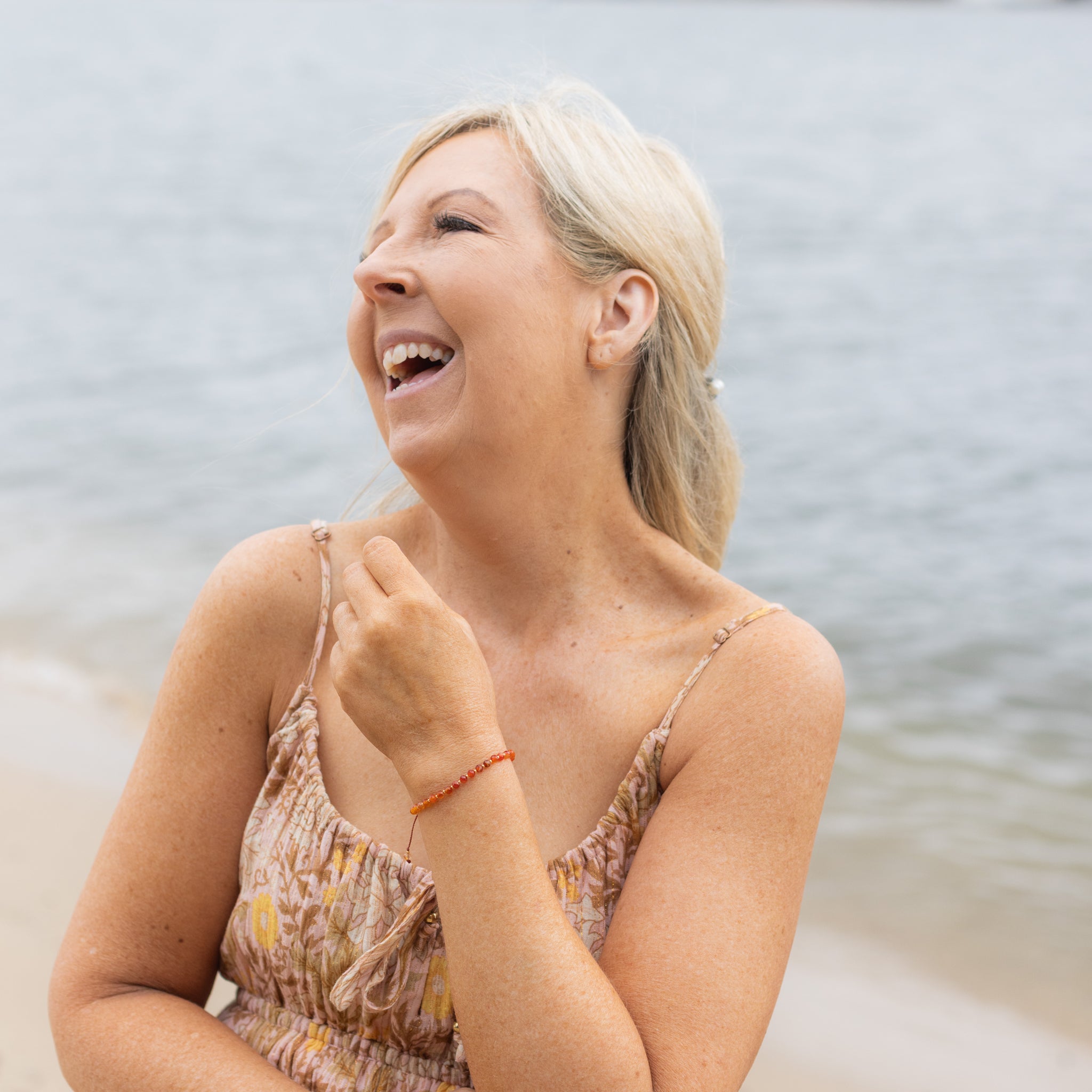 Intuitive Charms Coralia's Glow Carnelian Braided natural Crystal beaded custom Bracelet in silver and red cord on model further out
