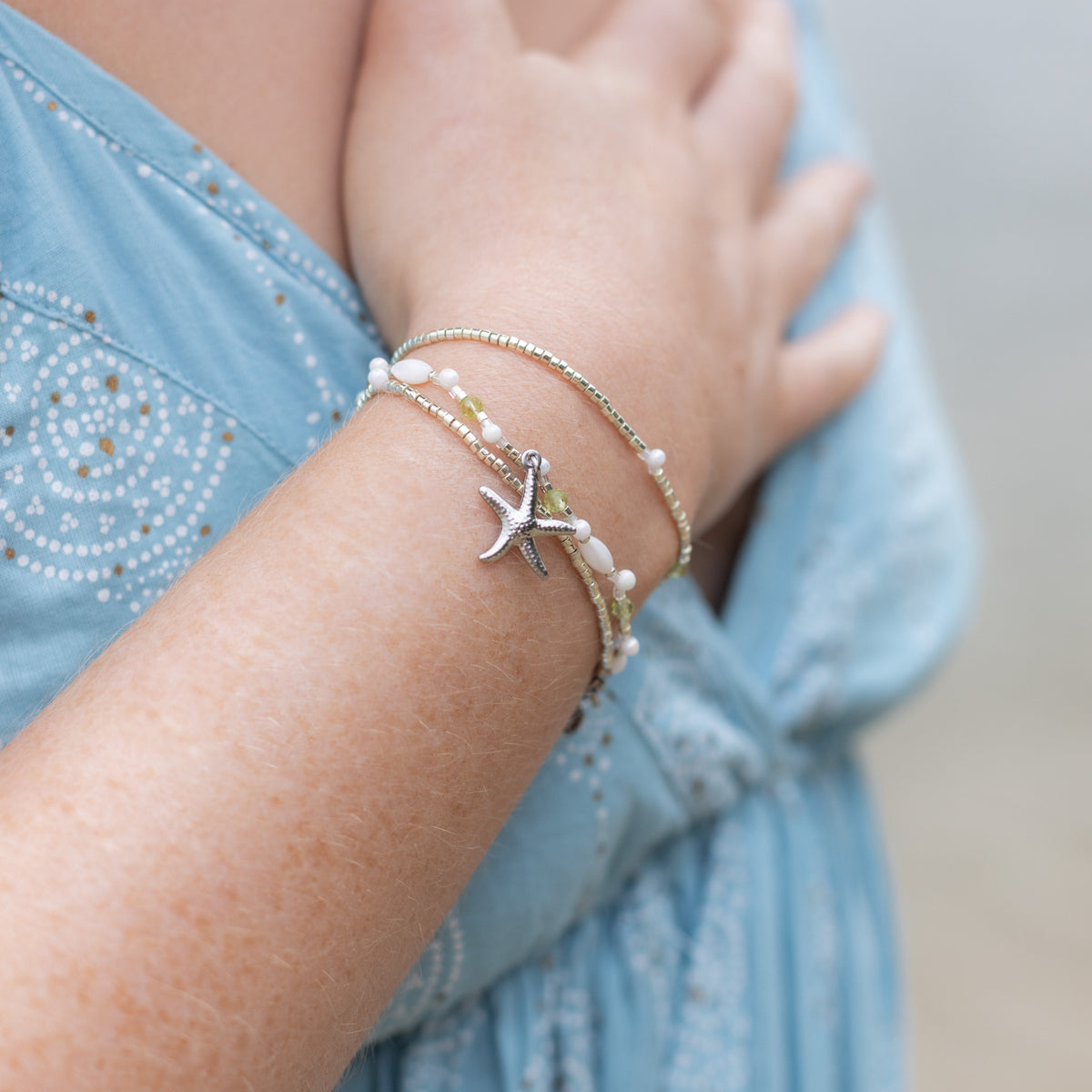 Intuitive Charms Nerina's Song Peridot natural Crystal beaded custom Bracelet in silver on model hand on chest close up